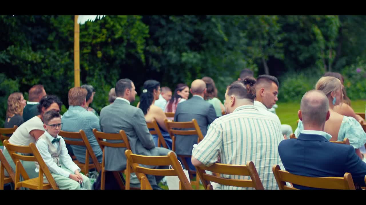 Videostill uit een trouwfilm: gasten bij een buitenceremonie